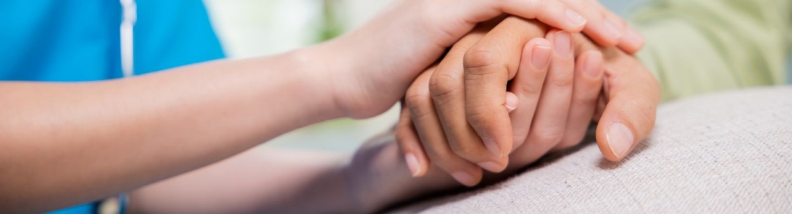 Symbolbild Pflege; eine Pflegerin hält die Hand einer Patientin